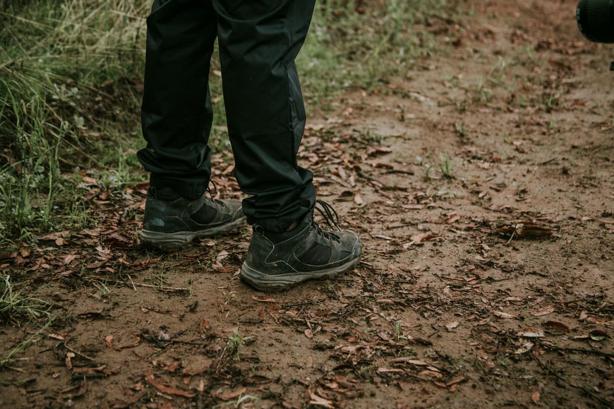 Hiking boots standing on a muddy trail
