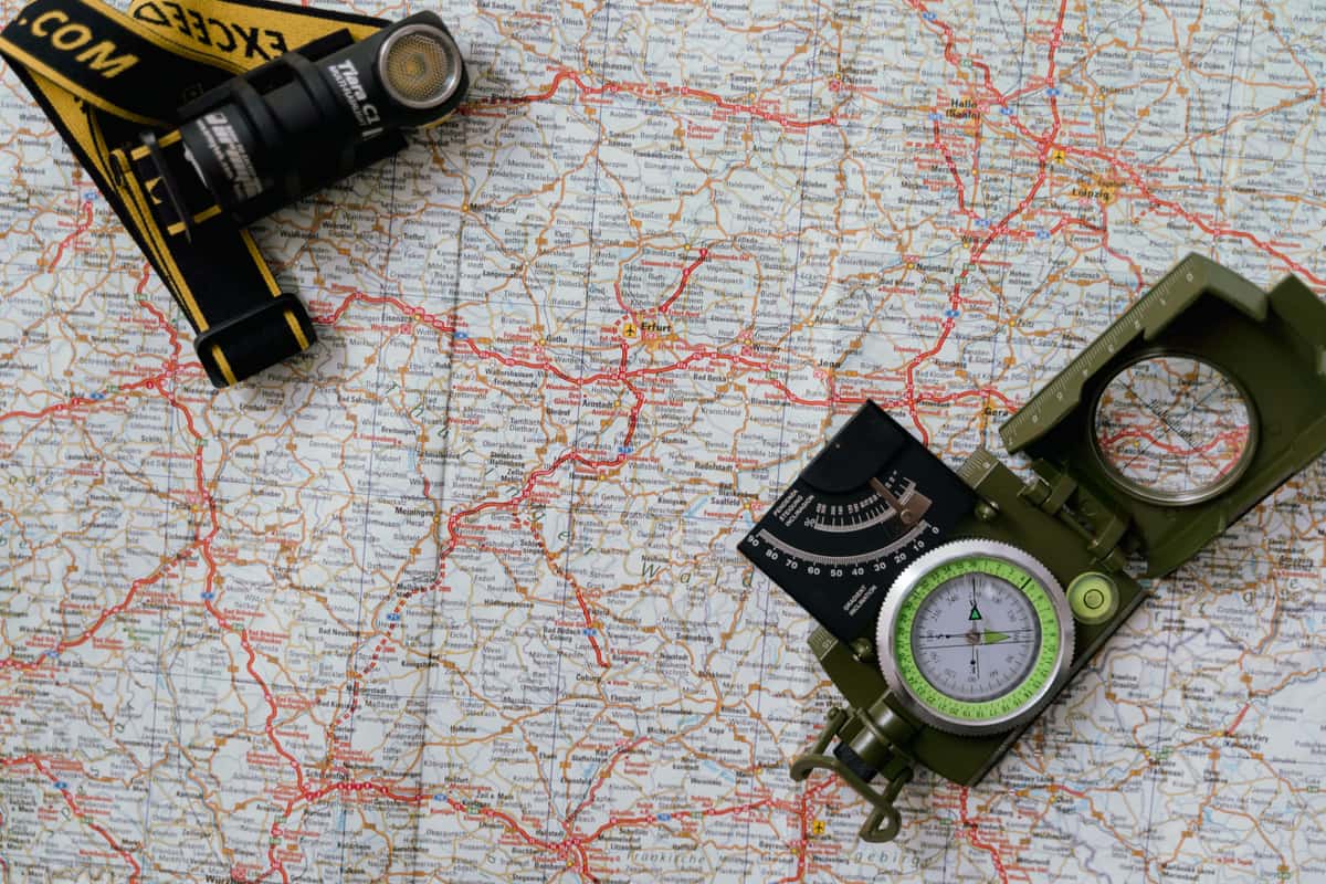A compass and a flashlight lying on a map